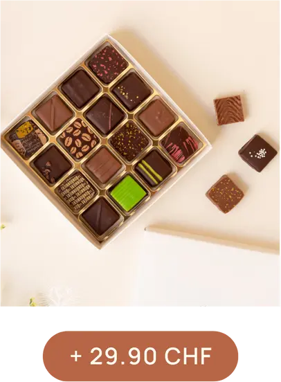Boîte carrée contenant divers chocolats ornés de motifs colorés, disposés en rangées. Quelques chocolats sont posés à côté. Texte : + 29.90 CHF.