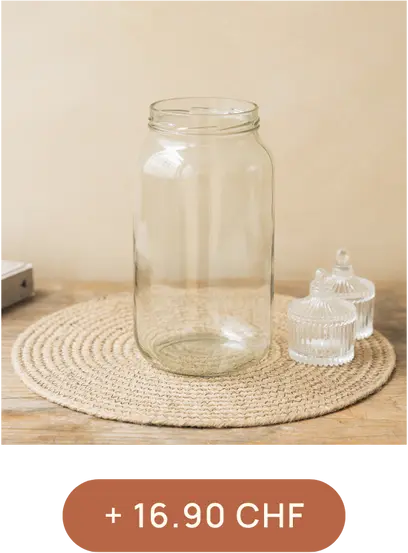 Un grand bocal en verre transparent est posé sur un napperon beige, accompagné de deux petits pots en verre cannelé avec des couvercles. Texte : "+16.90 CHF".